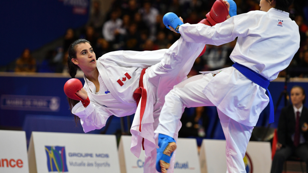 Une athlète de karaté donne un coup de pied à son adversaire.