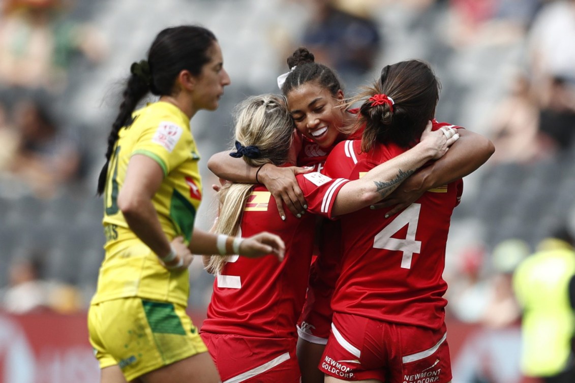 Trois joueuses canadiennes se font un câlin pour célébrer un point.