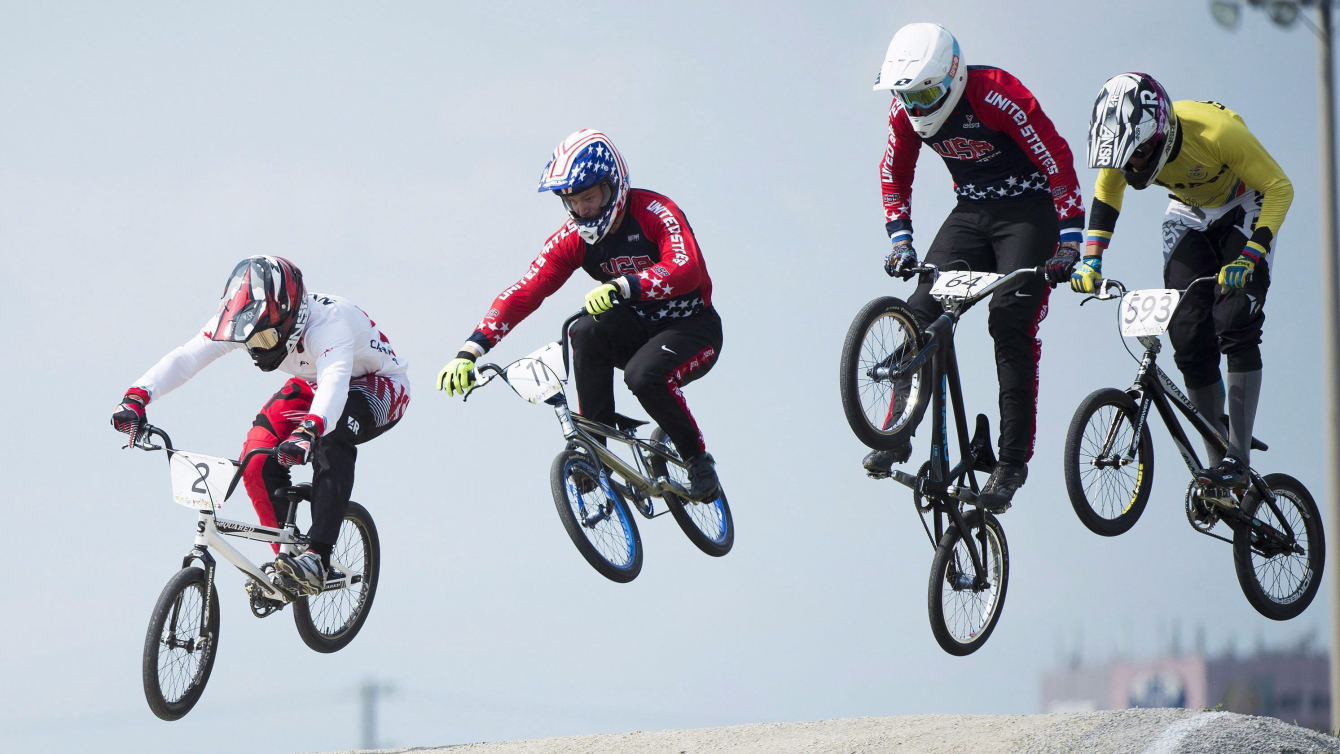 Quatre cyclistes de BMX en suspension dans les airs après un saut