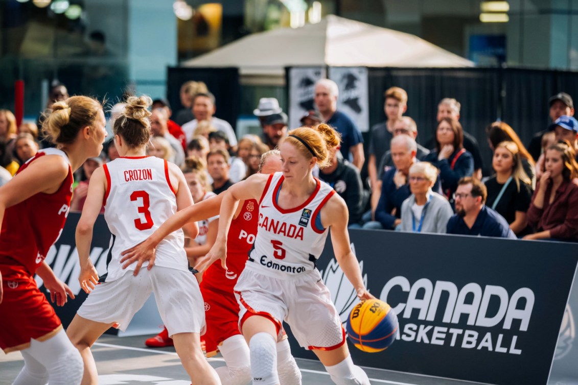 Une joueuse en possession du ballon tente d'éviter une adversaire